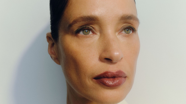 Image contains a model wearing eyeliner and a bold lip on a white background